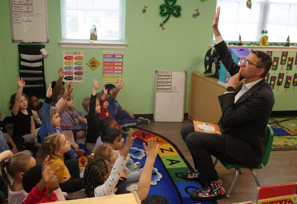 Governor Matt Meyer speaking to children in a classroom.